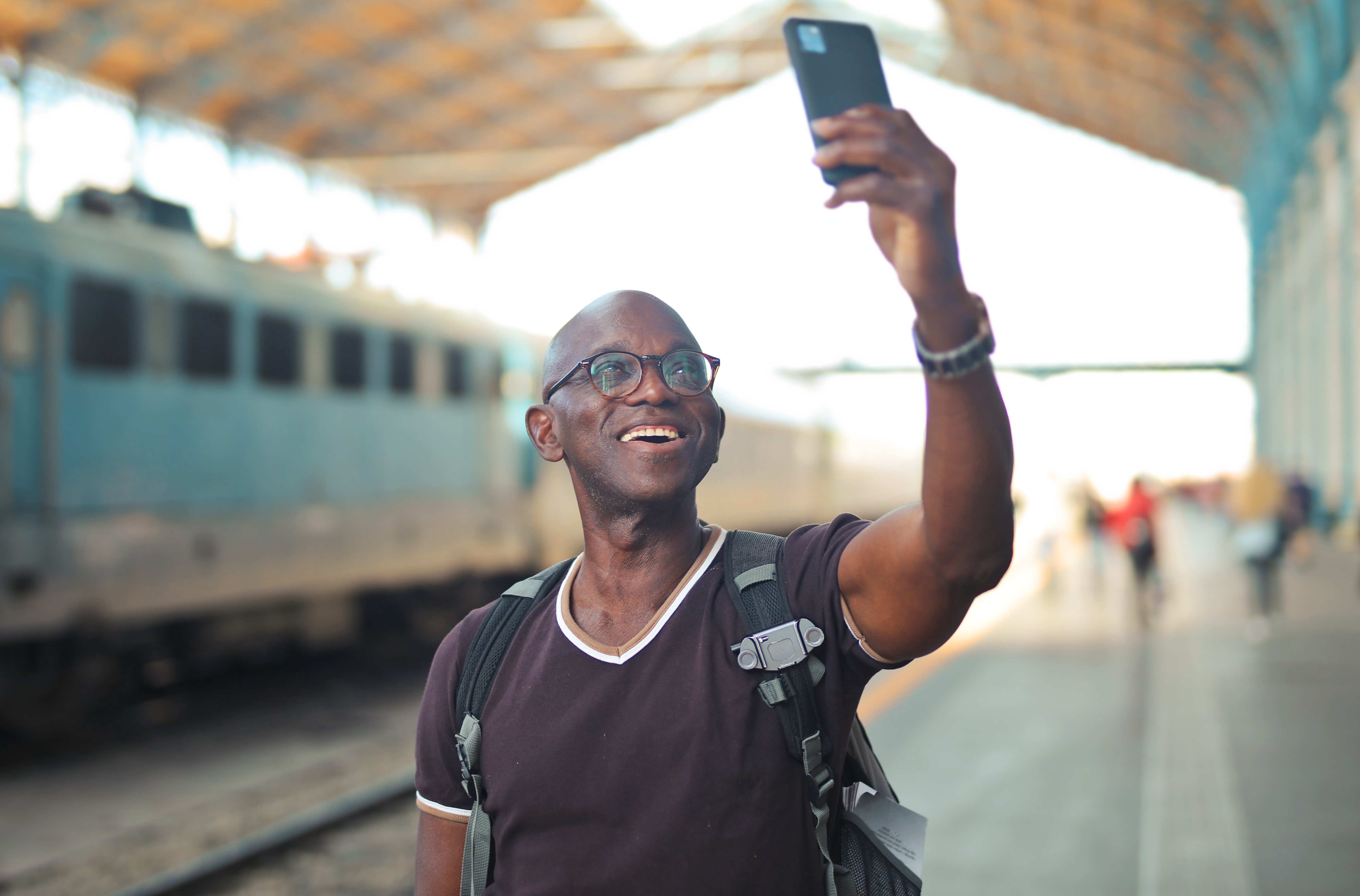 portrait of man in a train station while taking a selfie